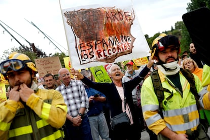 Una ciudadana porta una pancarta con la inscripción "Arde España por los recortes" en la concentración frente a las Cortes de Castilla y León.