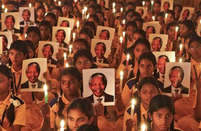 Chennai (India), 6 de diciembre de 2013. Con Mandela en el pensamiento. El expresidente de Sudáfrica, Nelson Mandela, falleció el 5 de diciembre. Su muerte fue muy sentida en el mundo entero. En la imagen, un grupo de niños de una escuela en Chennai, al sur de India, sujeta velas y fotografías del líder sudafricano.