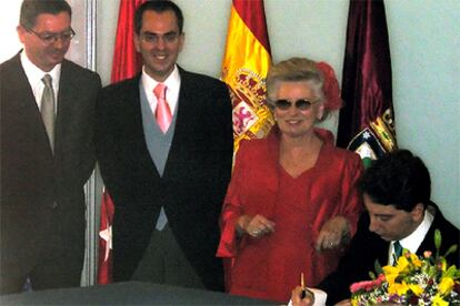 Manuel Ródenas firma el acta de matrimonio en presencia de su marido, Javier Gómez, y de Gallardón (a la izquierda).