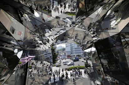 Los viandantes se reflejan en los espejos de un centro comercial del distrito de Harajuku, en Tokio (Japón).