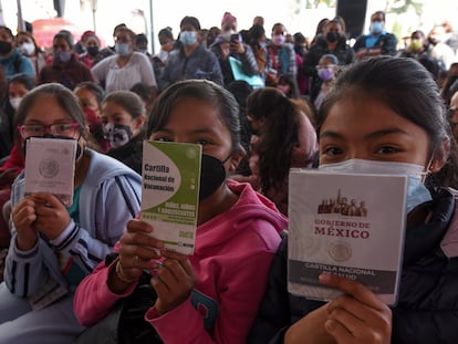 Tres adolescentes enseñan su cartilla de vacunación, durante un evento del Instituto de Salud del Estado de México.