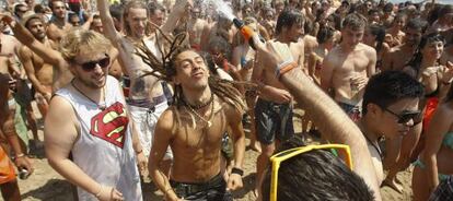 Asistentes al Rototom Festival bailan en el &#039;Sun Beach&#039; instalado en la playa del Torre&oacute;n.