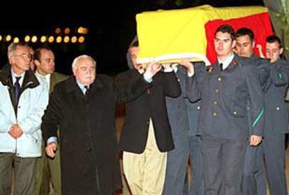 El cadáver de Julio Fuentes es transportado por familiares y militares a su llegada a Madrid.