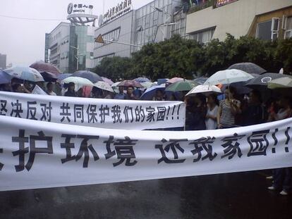 Manifestaci&oacute;n contra una f&aacute;brica de cobre en Shifang, el lunes. Las pancartas dicen: &quot;&iexcl;Proteged el medio ambiente, devolvednos nuestra tierra!&quot; y &quot;Protesta y &uacute;nete para defender nuestra tierra&quot;.