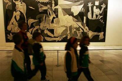 Un grupo de escolares pasa ante el <i>Guernica</i> en el Museo Reina Sofía.