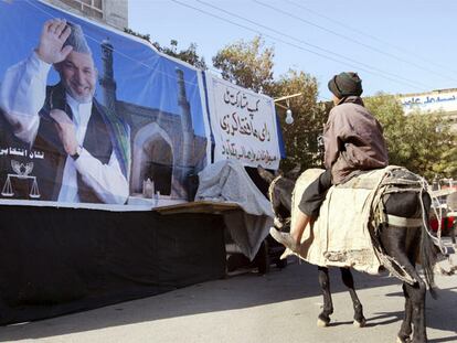 Un niño contempla un cartel del actual presidente afgano, Hamid Karzai, en Herat, al oeste del país.