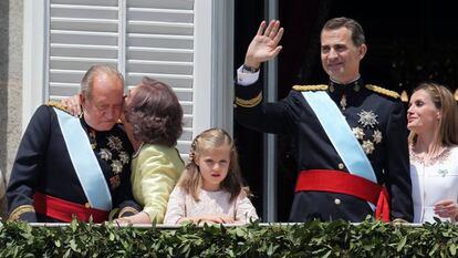 La reina Sofía besa al rey Juan Carlos en el balcón del palacio Real de Madrid, mientras el rey Felipe saluda al público congregado en la plaza de Oriente, junto a la princesa Leonor y la reina Letizia tras la proclamación del rey Felipe VI, el 19 de junio de 2014.