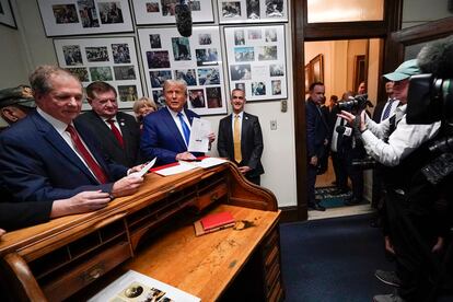 Republican presidential candidate former President Donald Trump talks with New Hampshire Secretary of State David Scanlan, right, as he signs papers to be on the 2024 Republican presidential primary ballot at the New Hampshire Statehouse, Monday, Oct. 23, 2023, in Concord, N.H.