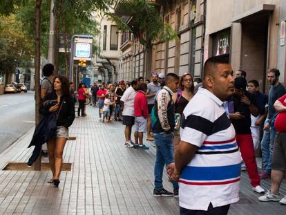 Decenas de personas hacen cola ante una comisar&iacute;a de Barcelona para conseguir cita para el DNI, en una imagen de julio de 2016.