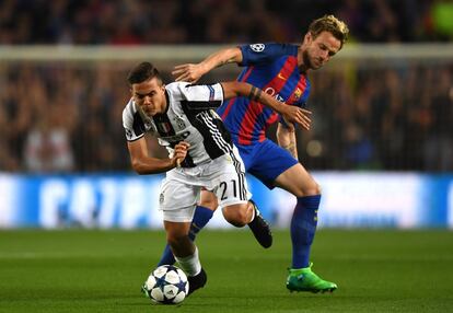 Paulo Dybala de la Juventus se hace con el balón seguido por Ivan Rakitić.
