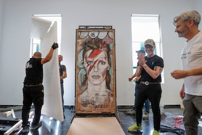 El artista Jesús Arrúe (segundo ala derecha), asiste a la instalación del grafiti de David Bowie, en L'Etno.