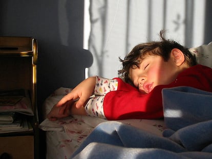 Un niño duerme plácidamente en su cama.