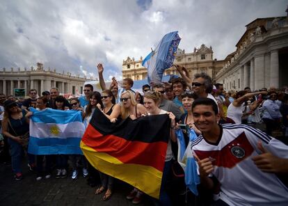Aficionados alemanes y argentinos animan a sus selecciones desde la Plaza de San Pedro del Vaticano antes de que el papa Francisco oficie el Ángelus.