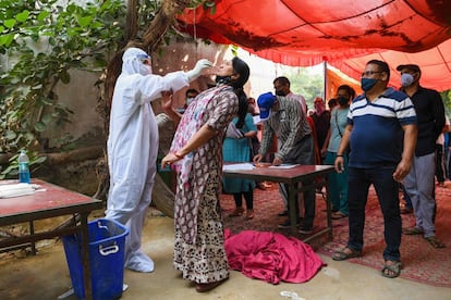 Un trabajador sanitario recoge muestras para detectar a las personas infectadas por coronavirus, en Ghaziabad (India).