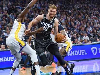 Domantas Sabonis entra a canasta ante Draymond Green, en el partido entre los Kings y los Warriors.