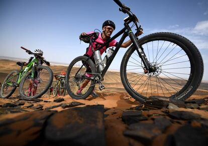 Dos participantes empujan sus bicicletas durante la segunda etapa, el 20 de abril de 2019, en Ouzina (Marruecos).