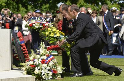  El gobernador general de Nueva Zelanda, Jerry Mateparae (izq), el primer ministro brit&aacute;nico, David Cameron (c), y su hom&oacute;logo australiano, Tony Abbot, depositan una corona de flores durante la ceremonia franco-brit&aacute;nica en el cementerio militar brit&aacute;nico en Bayeux (Francia).