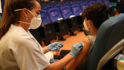 A health worker vaccinates a teenager in Madrid in August.