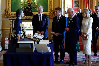 El presidente de Francia, Emmanuel Macron, y su esposa, Brigitte Macron, junto al rey Carlos III del Reino Unido, observan una exposición de arte de la Colección Real en el Castillo de Windsor.
