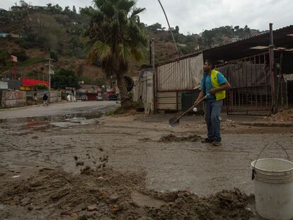 José Guzmán cleans up mud in the streets of Los Laureles in Tijuana after a night of rain; November 15, 2023.