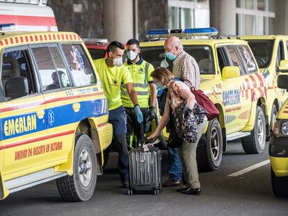 Dos viajeros reciben asistencia de los servicios de emergencias tras desembarcar en Lanzarote del vuelo procedente de Madrid en el que uno de los ocupantes ha dado positivo en covid-19.