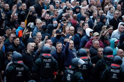 Manifestantes de ultraderecha se enfrentan a la policía alemana con el puño en alto.