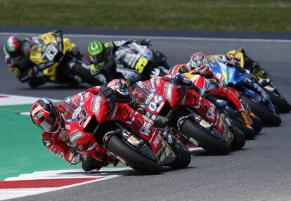 Danilo Petrucci (en primer término) encabezando la carrera y seguido por Márquez y Alex Rins.