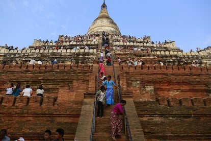 Cuando se acerca la puesta de sol no queda un hueco libre en la pagoda de Shwesandaw, contruida por el rey Anawrahta en el año 1057. Los turistas, equipados con cámaras y móviles de última generación, toman posiciones en este templo piramidal con escaleras que ascienden a través de cinco terrazas. Fotografían extasiados el ocaso desde la más admirada de las 2.000 construcciones budistas que se extienden por la llanura de Bagan. La afluencia de viajeros a este yacimiento arqueológico de Myanmar, la antigua Birmania, sirve de termómetro para medir la apertura del país, que durante casi 50 años vivió una brutal dictadura militar. Desde su final, en 2011, Myanmar se está beneficiando del auge del turismo, y Bagan es su reclamo más preciado. Como dicen quienes lo han visto, nada te prepara para un atardecer allí.