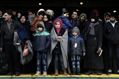 Un grupo de refugiados espera para desembarcar de un ferri, procedentes de una isla, el s&aacute;bado en el puerto del Pireo, en Atenas. 