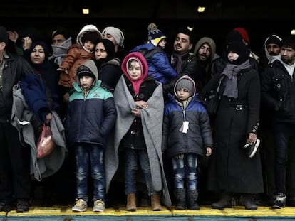 Um grupo de refugiados procedente de uma ilha grega aguarda para desembarcar de uma balsa no porto de Pireus, nos arredores de Atenas, no sábado.