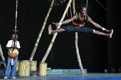 Un músico toca la kora mientras un bailarín ejecuta una acrobacia durante la presentación del espectáculo del Circus Baobab <i>Le singe de Saudieu.