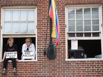 Acivistas con carteles contra el líder de la oposición venezolana Juan Guaidó. 