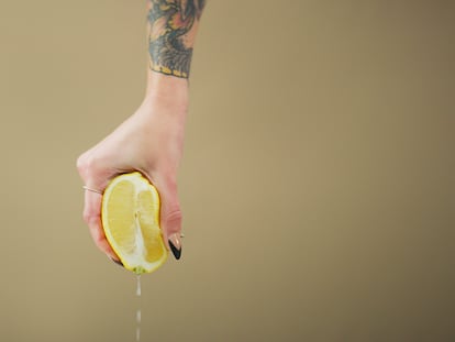 Una mujer exprime un limón.