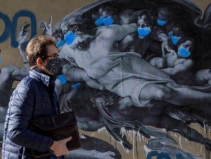 Un hombre pasa ante un mural del artista callejero Sentydo, en Pola de Siero (Asturias).