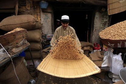 Un vendedor paquistaní prepara cacahuetes para la venta en las inmediaciones de una carretera en Peshawar (Pakistán).