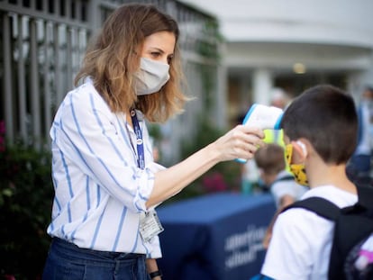 Una trabajadora toma la temperatura a un niño a la entrada del colegio privado internacional American School of Barcelona.