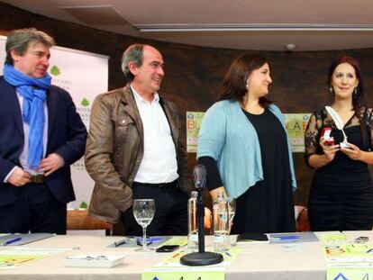 Dolores Redondo sostiene la Pluma de Plata en presencia de los organizadores de la Feria del Libro de Bilbao. 