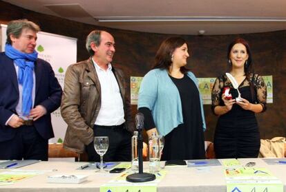 Dolores Redondo sostiene la Pluma de Plata en presencia de los organizadores de la Feria del Libro de Bilbao. 