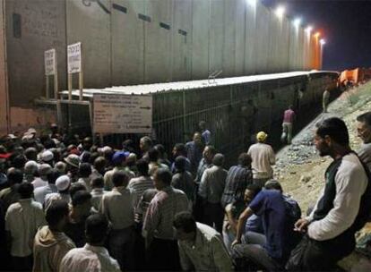 Trabajadores palestinos aguardan para cruzar el muro y entrar en Jerusalén desde la localidad cisjordana de Belén.