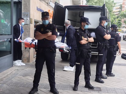 Dos operarios transportan el cuerpo de uno de los tres muertos, el 20 de junio en Madrid.