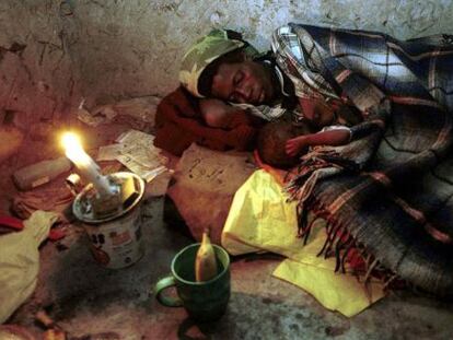 Una mujer descansa con su hijo, ambos afectados de sida, en Magomba (Suazilandia).