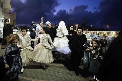 Family members lead Ultra-Orthodox Jewish bride Parowol Mirel Lamber, from the Toldos Avrohom Yitzchok (Hasidic dynasty), to marry the great-grandson of the Rabbi of the Tzanz Ultra-Orthodox Hasidic community at a wedding ceremony on March 15, 2016, in the Israeli central city of Netanya. / AFP PHOTO / MENAHEM KAHANA