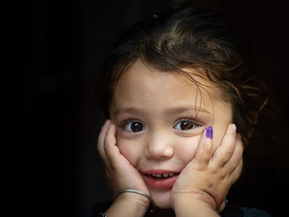 Gul-e-Rukh, de cuatro años, posa mostrando su dedo marcado que indica que ha sido vacunada contra la polio, en Karachi, Pakistán.