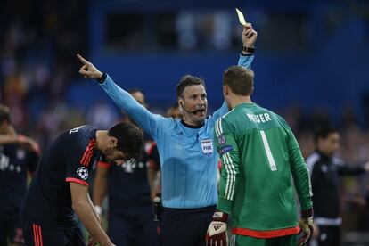 El arbitro Mark Clattenburg muestra tarjeta amarilla al jugador Manuel Neuer del Bayern.