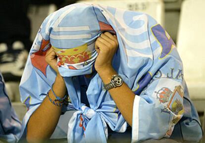 Un aficionado del Celta cubre su cabeza con una bandera tras el descenso de su equipo.