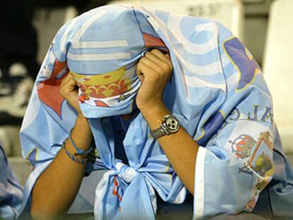 Un aficionado del Celta cubre su cabeza con una bandera tras el descenso de su equipo.