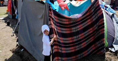 Un ni&ntilde;o afgano sujeta su tienda en un campo levantado en Horgos (Serbia, cerca de la frontera con Hungr&iacute;a).