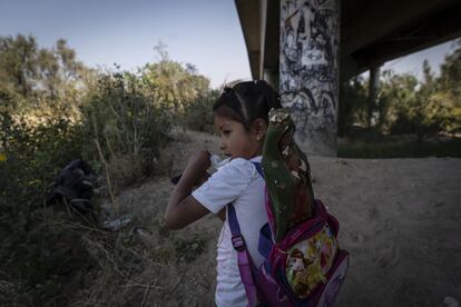La pequeña Nayeli, de 6 años de edad, bebe un poco de agua bajo un puente del Municipio de Nezahualcóyotl, Estado de México. Viaja con su familia como cada año para visitar a la Virgen de Guadalupe en la capital del país.
