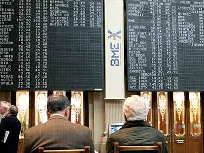 Dos inversores miran los paneles informativos de la Bolsa de Madrid.