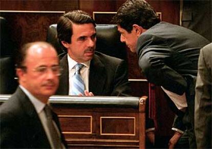 José María Aznar charla con el ministro de Defensa, Federico Trillo-Figueroa, ayer en el Congreso.
